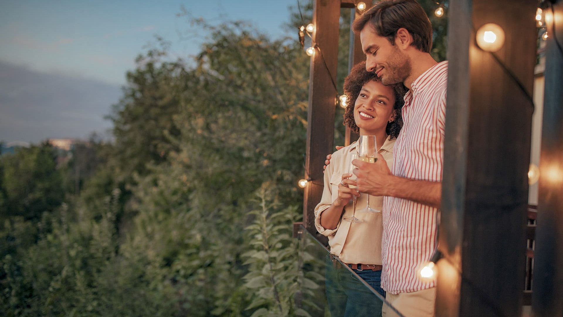 Couple having an aperitif at sunset while sharing a glass of wine on the terrace, a moment of pure romanticism.