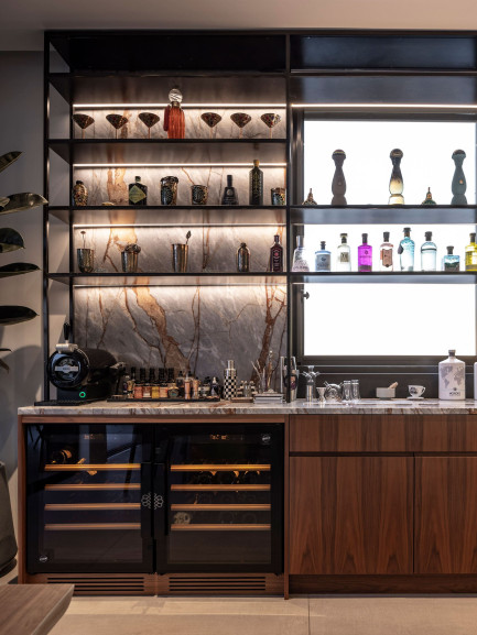 Two small EuroCave Compact wine coolers with glass doors, built under a bar counter, integrated into wood cabinetry with a marble countertop, elegant contemporary ambiance.