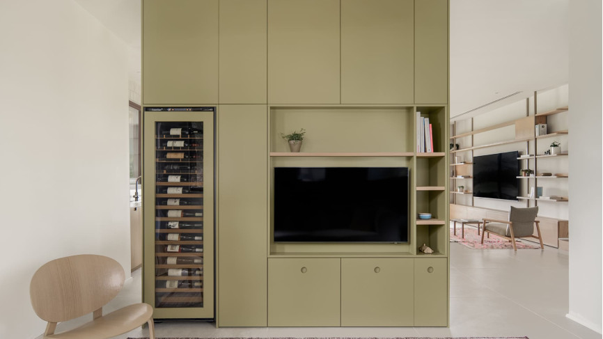 Built-in wine cooler with glass door and integrated controls, installed in a custom living room cabinet serving as a room divider - Inspiration EuroCave